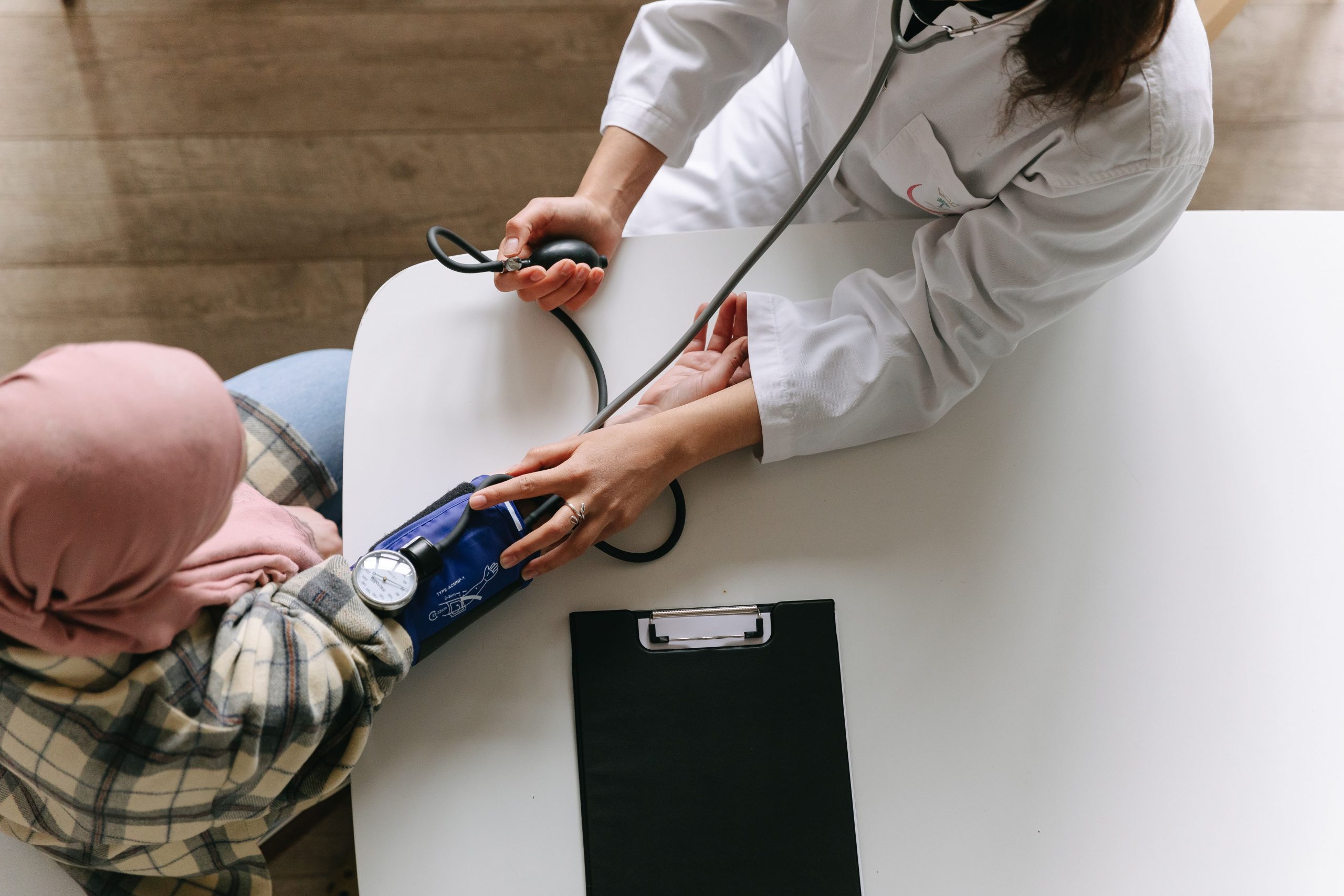 A doctor is holding the stethoscope of a patient.